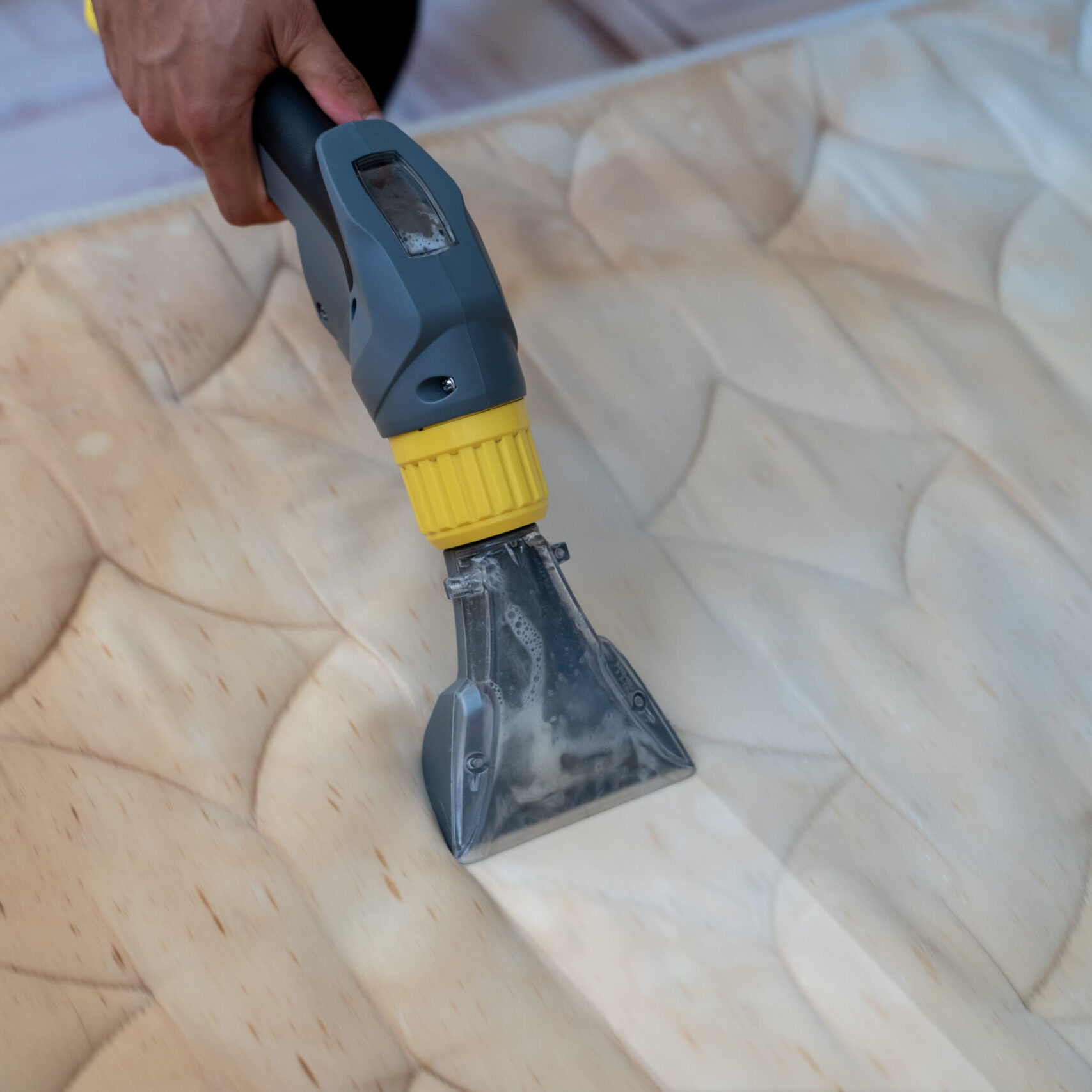 Mattress cleaning machine and cleaning detail shot. Yellowed mattress washing by professional machine